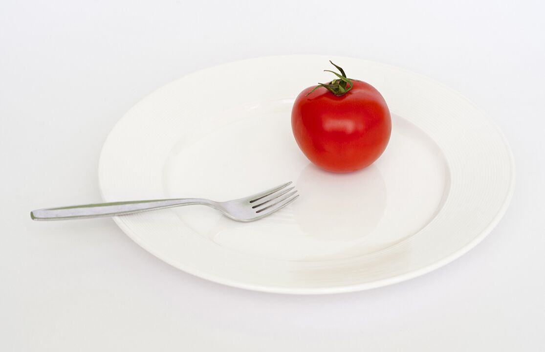 Tomato with a fork on a plate